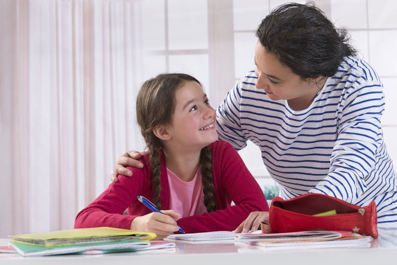 Girl smiling at her Mum while doing revision