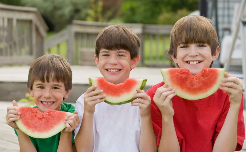 Happy kids eating melons