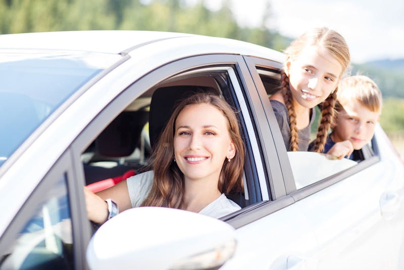 Kids smiling at their mum in the car