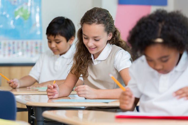Girl smiling at a test she is taking in class