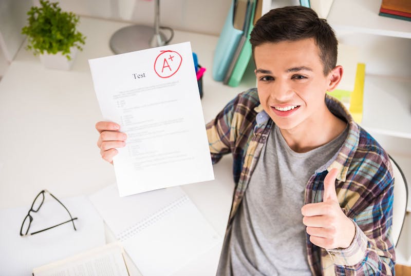 Boy happy having achieved an A+ in their test